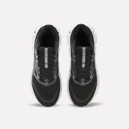 The Reebok Men's FloatZig 2 Running Shoes feature a black design with white soles, gray accents, black laces, mesh toe detailing, and Superfloat+ cushioning. Shown from above against a plain white background.