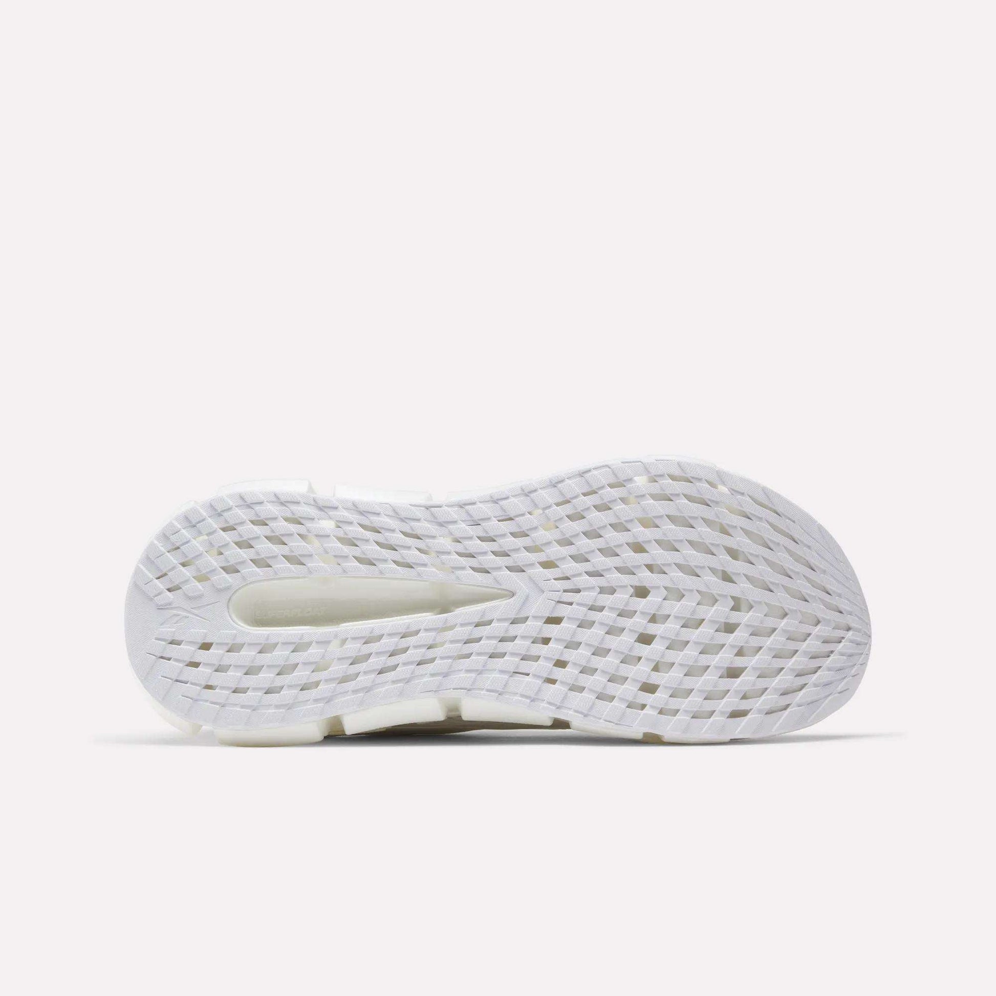 The image shows the bottom view of a white Reebok Men's FloatZig 2 Running Shoe sole with grid-like textured grooves, a central cutout for traction and flexibility, and energy-returning cushioning on a light gray background.