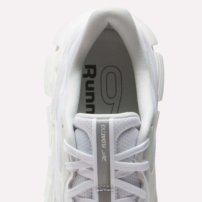 Top view of a white Reebok Men's FloatZig 2 Running Shoe with white laces. "Runner 9" is on the insole, and "FLOATZIG" plus logo appear on the tongue, emphasizing energy-return cushioning for superior comfort.