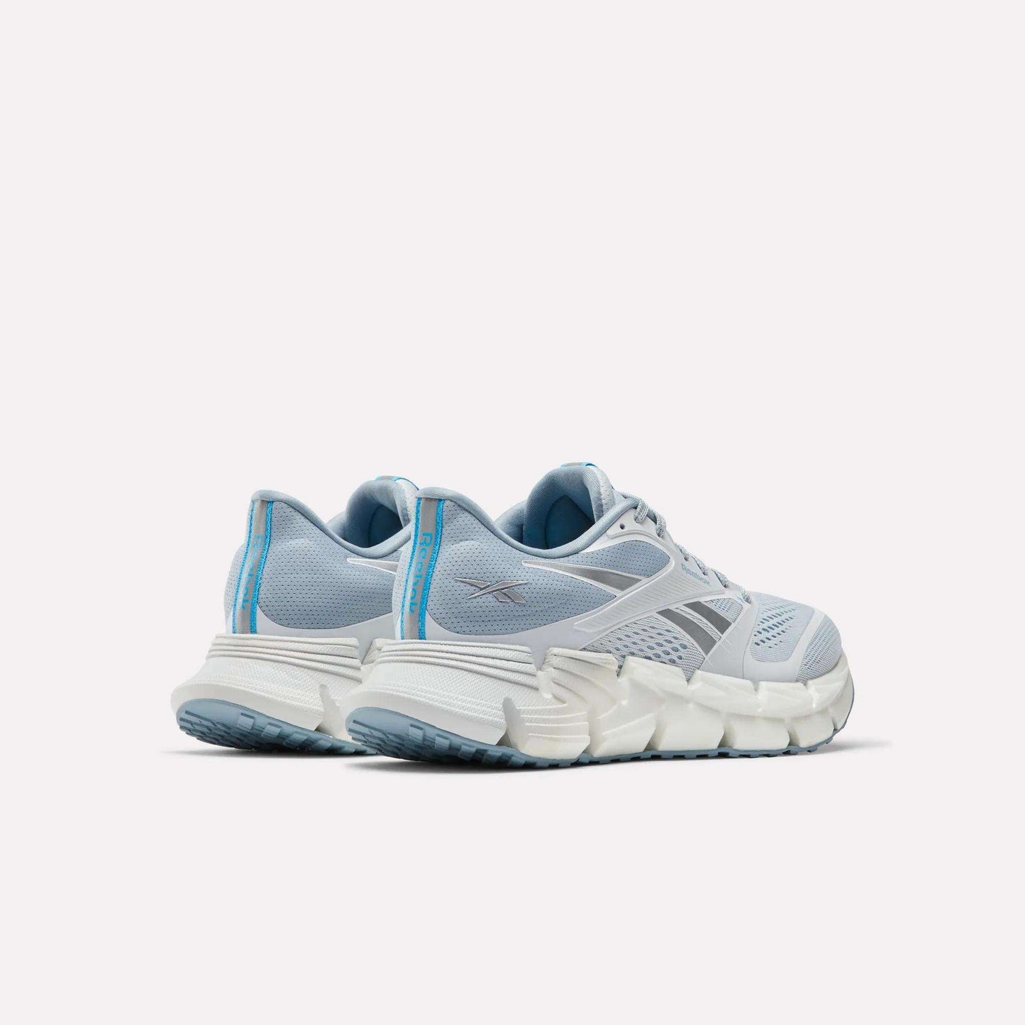 A pair of Reebok Women's FloatZig 2 Running Shoes in light blue with white chunky soles and FloatZig cushioning, shown from the back and side on a plain white background.