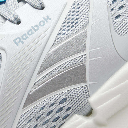 Close-up of Reebok Women's FloatZig 2 Running Shoes in white and silver, showing mesh and synthetic upper, detailed stitching, side Reebok logo, and a carbon rubber outsole for lasting traction.