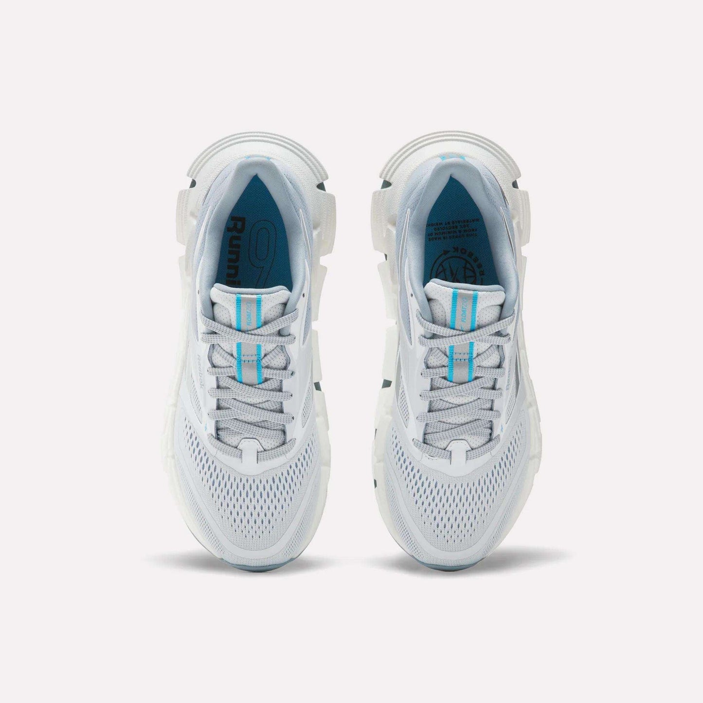 A pair of Women's FloatZig 2 Running Shoes by Reebok with white mesh uppers, light blue accents, gray details, Superfloat+ cushioning, and carbon rubber soles is shown from above on a plain white background.