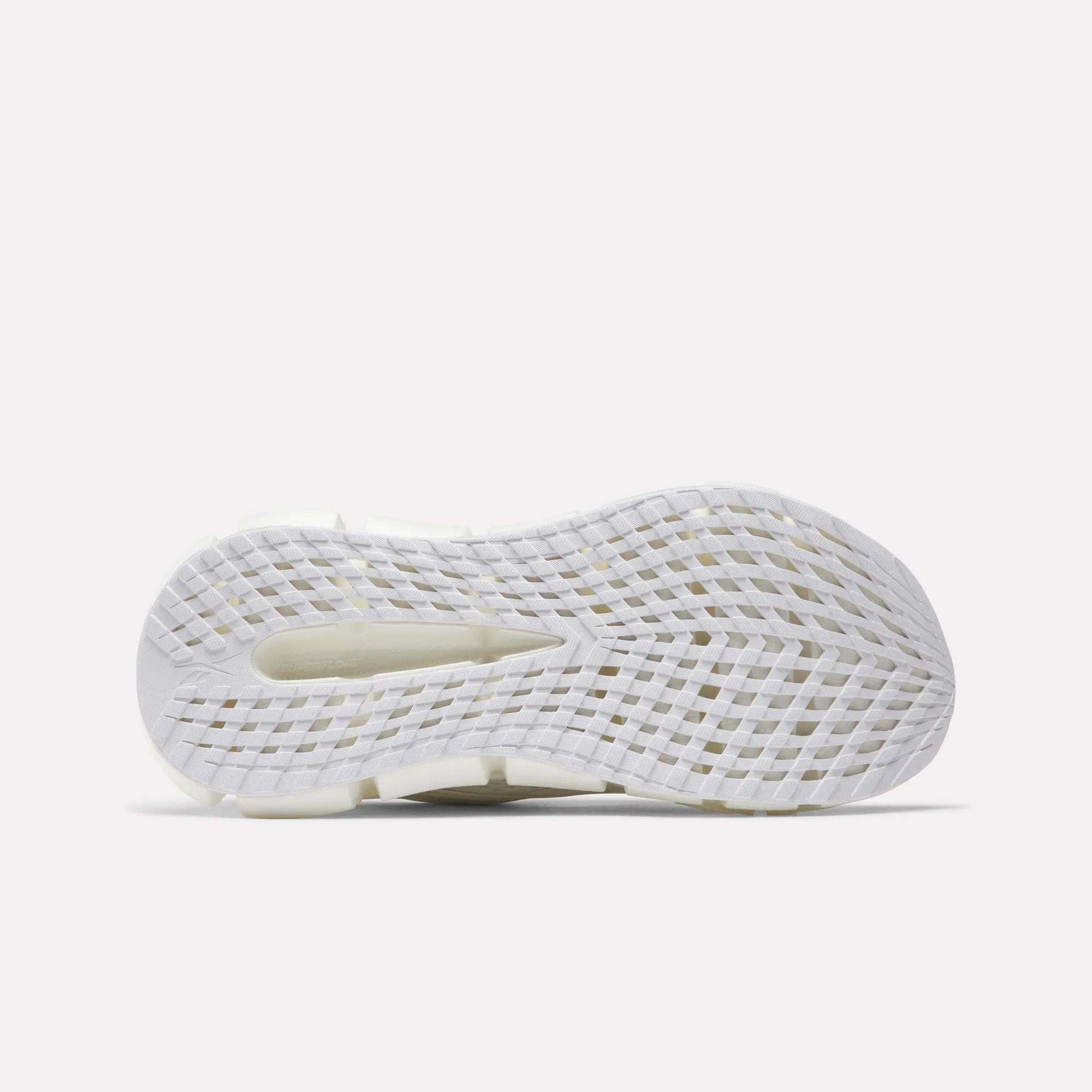 The image displays the white, textured sole of Reebok Women's FloatZig 2 Running Shoes. It features a grid-like traction pattern, a heel cutout, and Superfloat+ cushioning against a plain light background.