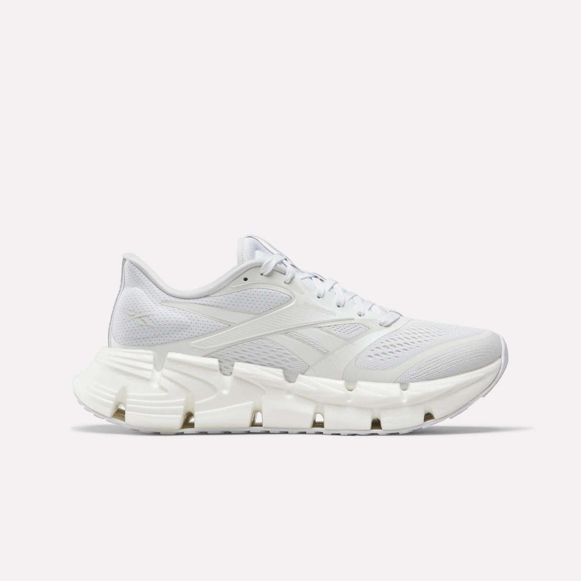 The Reebok Women's FloatZig 2 Running Shoes feature a white breathable mesh upper, tonal laces, and a sculpted rubber sole with Superfloat+ cushioning, shown in side profile on a plain white background.
