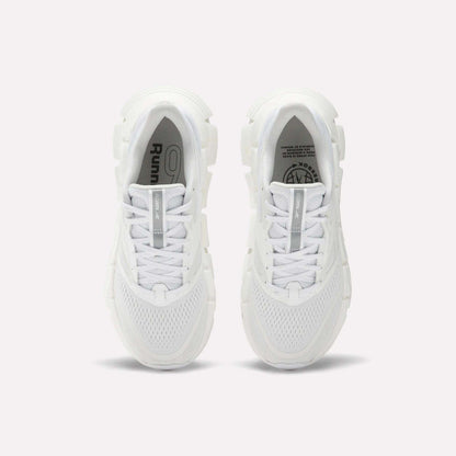 A pair of Women's FloatZig 2 Running Shoes by Reebok viewed from above, featuring white mesh uppers, chunky Superfloat+ cushioned soles, and white laces. The insoles show Reebok branding and graphic details.