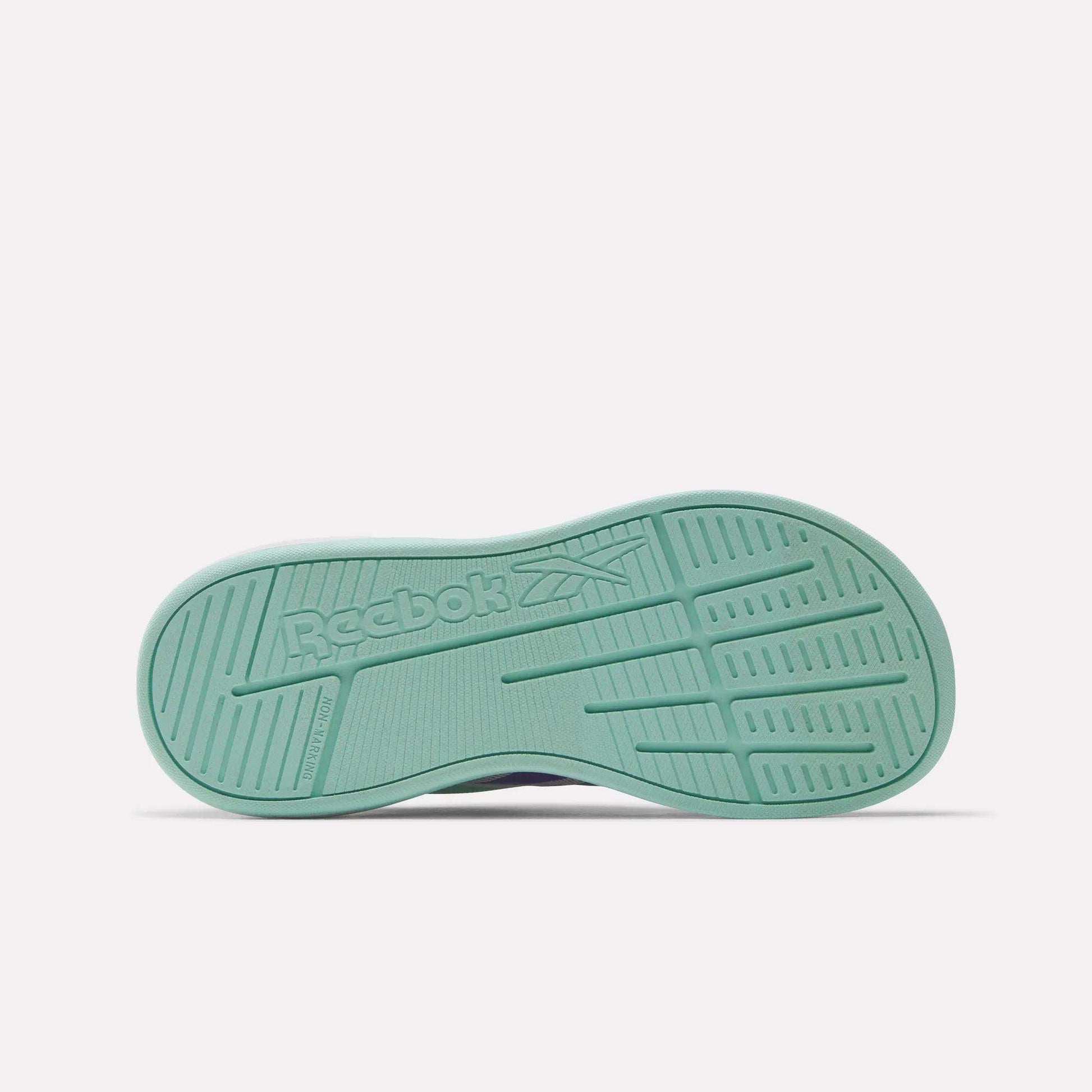 The image shows the sole of the Reebok Nano Play Slip-On Shoes for little kids, featuring a textured mint green surface with the Reebok logo and vector symbol embossed in the center.