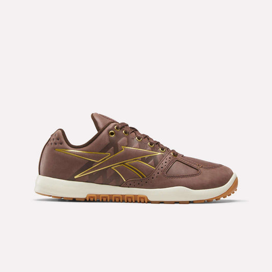 The Reebok Nano 2.0 Training Shoes in brown feature pebbled leather, gold accents, a white midsole, and a gum sole, shown in side profile on a plain light background.