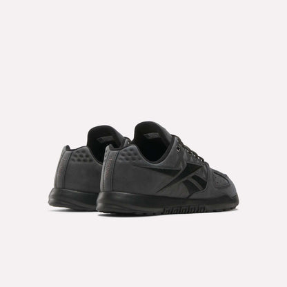 The Reebok Nano 2.0 Training Shoes, shown in black with a low-top design and pebbled leather detail, are displayed from back and side views against a plain white background.