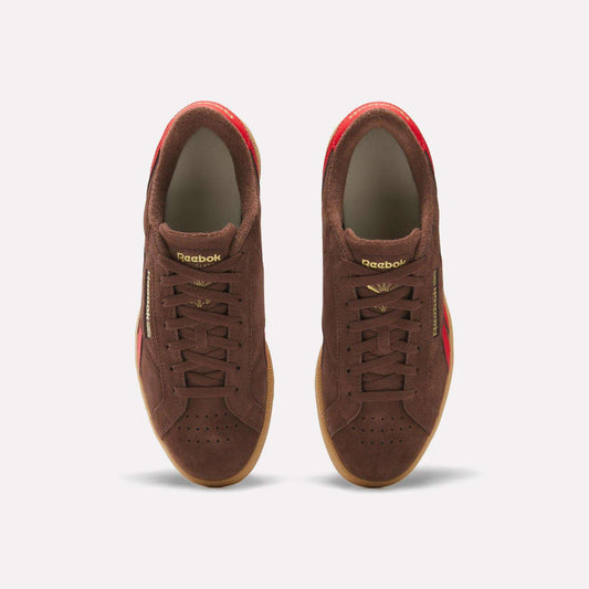 The Reebok Club C Grounds UK Shoes feature a brown suede upper, gold lettering, and red accents—archive-inspired sneakers that showcase classic Reebok heritage, shown from above on a plain white background.