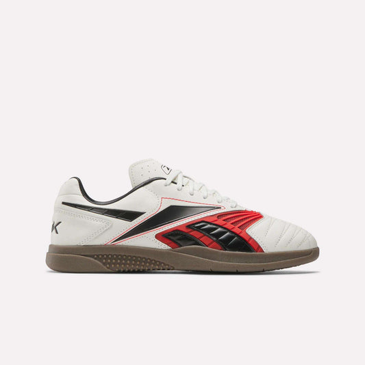The Reebok Hammer Valde Shoes are white indoor soccer boots with red and black accents, a lace-up leather upper, low profile gum rubber sole, visible stitching, and classic Reebok branding on the side and heel.