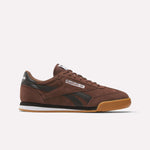 The Reebok Campio XT Shoes feature a brown upper with black accents, white side branding, a black heel tab, and gum rubber sole for '90s soccer style, shown against a plain white background.