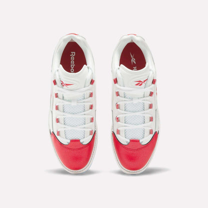 A pair of Reebok Question Golf Shoes viewed from above, showcasing white uppers with bright red accents on the toe, heel, and sides—these stylish spikeless shoes feature white laces threaded through red and white eyelets.