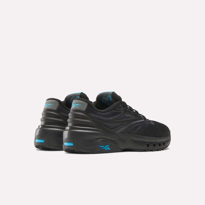 A pair of Reebok Men's ERS Training Shoes in black with blue accents and chunky soles, featuring premium cushioning. Displayed on a light background, the heels face forward and are slightly turned to the right.