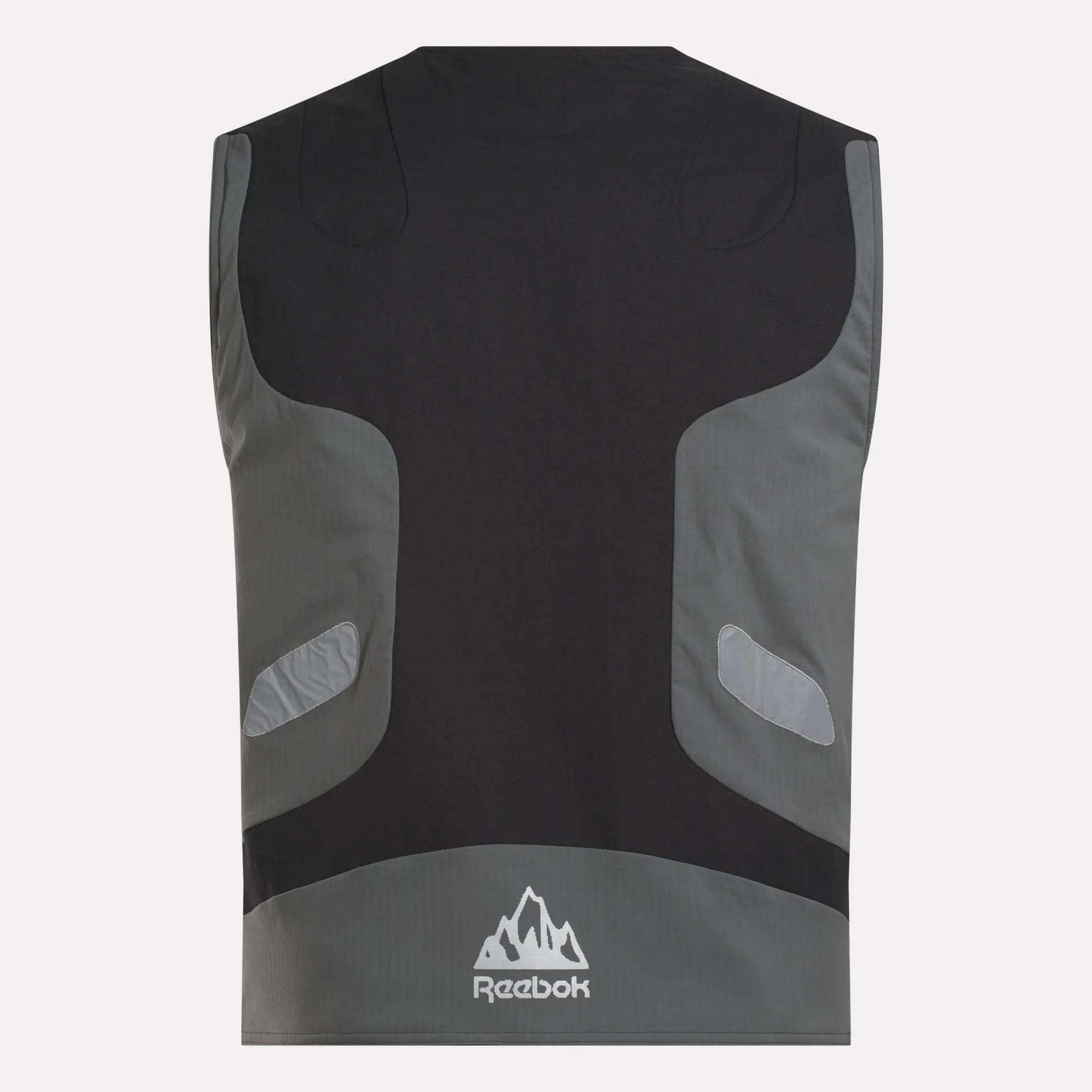 The Reebok x MARKET Reversible Vest is shown from the back in black and gray with reflective accents, a mountain-shaped Reebok logo near the hem, and a streetwear-inspired design.