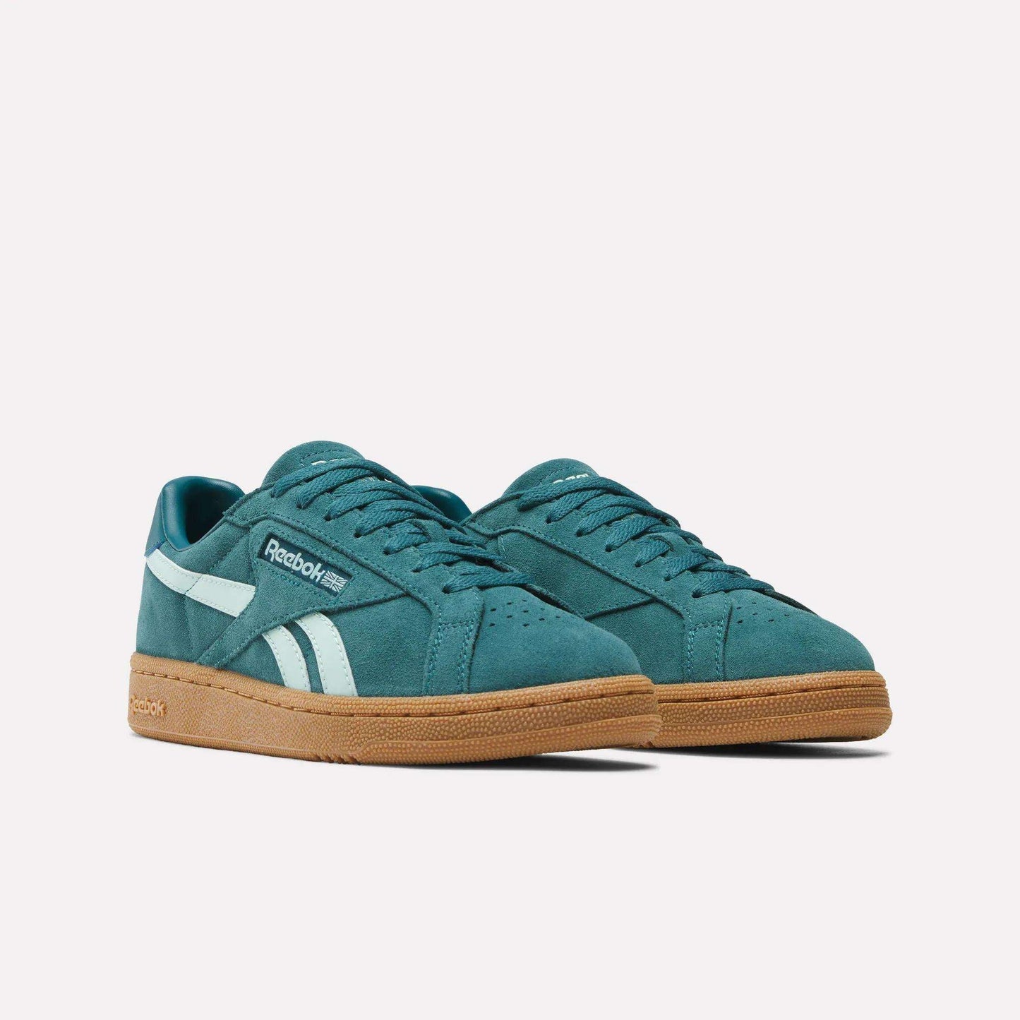 The Women's Club C Grounds UK Shoes by Reebok feature a teal suede upper, white side stripes, and gum rubber soles, shown against a plain white background.