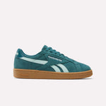 The Women's Club C Grounds UK Shoes by Reebok feature a turquoise suede upper, white stripes and logo, teal laces, and a brown rubber sole. They're showcased against a simple white background.
