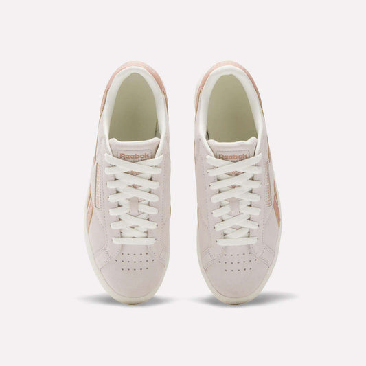 A top view of the Reebok Women's Club C Grounds UK Shoes in light pink, featuring white laces, beige details, suede and leather accents, and the Reebok logo on the tongue.