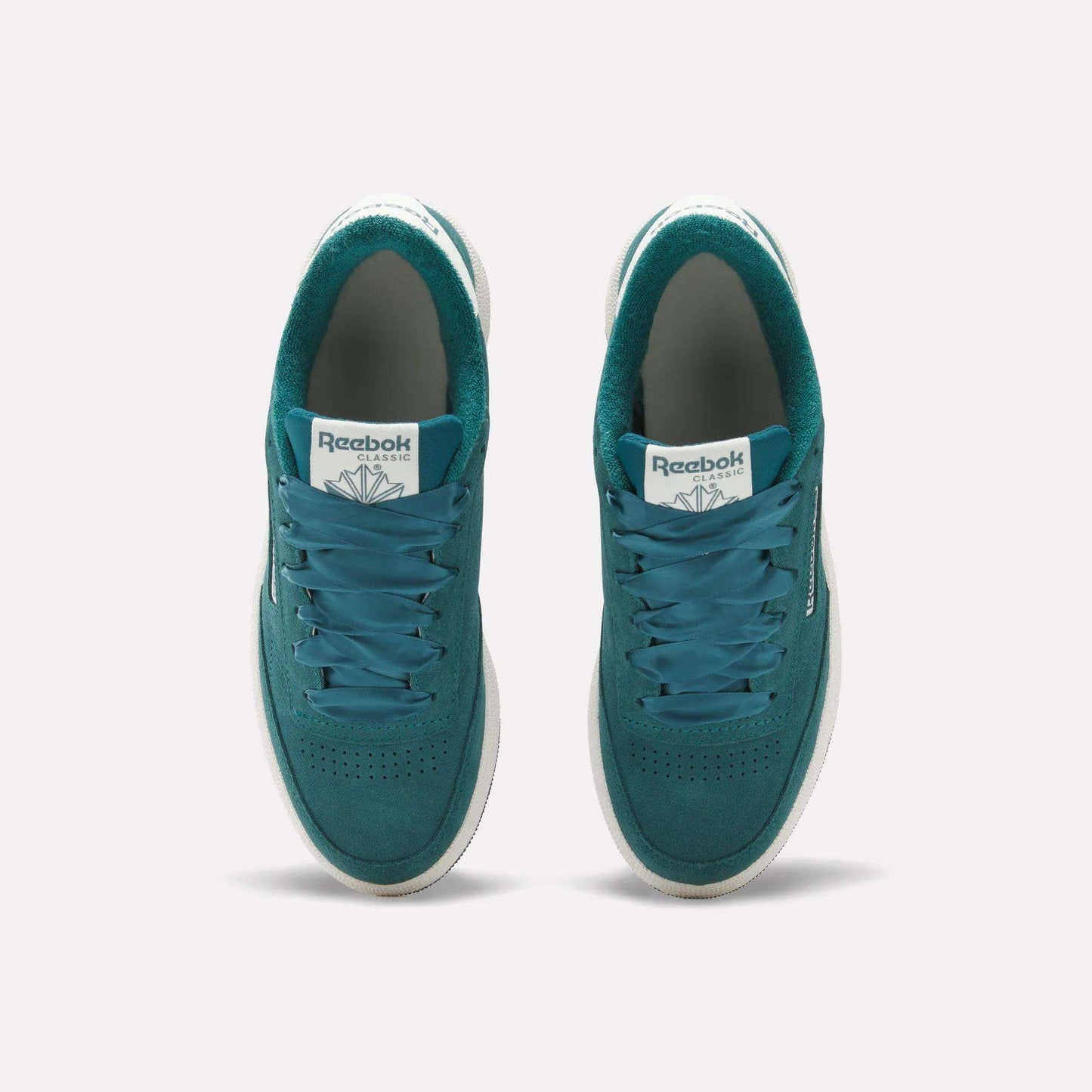 Top view of Reebok Women's Club C 85 Shoes in teal, featuring white midsoles, teal laces, and perforated toe boxes, set side by side on a plain light background.