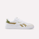 The Smash Edge Shoes are white Reebok sneakers with green and gold accents, featuring a suede T-toe, side logo, white laces, and a flat white sole—classic indoor soccer-inspired style shown on a plain light background.