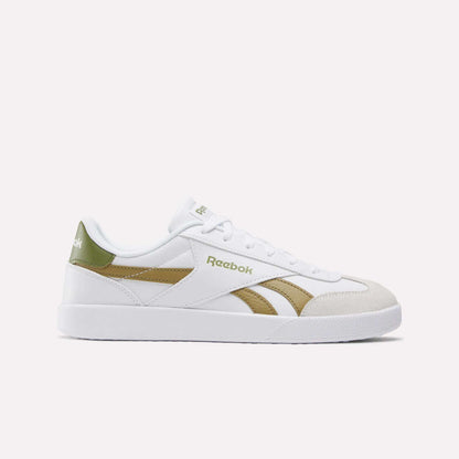 The Smash Edge Shoes are white Reebok sneakers with green and gold accents, featuring a suede T-toe, side logo, white laces, and a flat white sole—classic indoor soccer-inspired style shown on a plain light background.