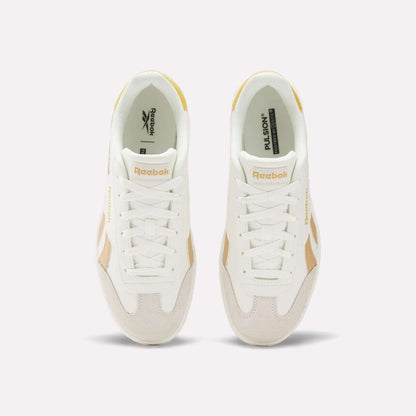 Top view of Reebok Smash Edge Shoes in white with beige details, displaying the Reebok logo on tongue and side, set against a plain light background. Ideal for those seeking stylish and comfortable indoor soccer footwear.