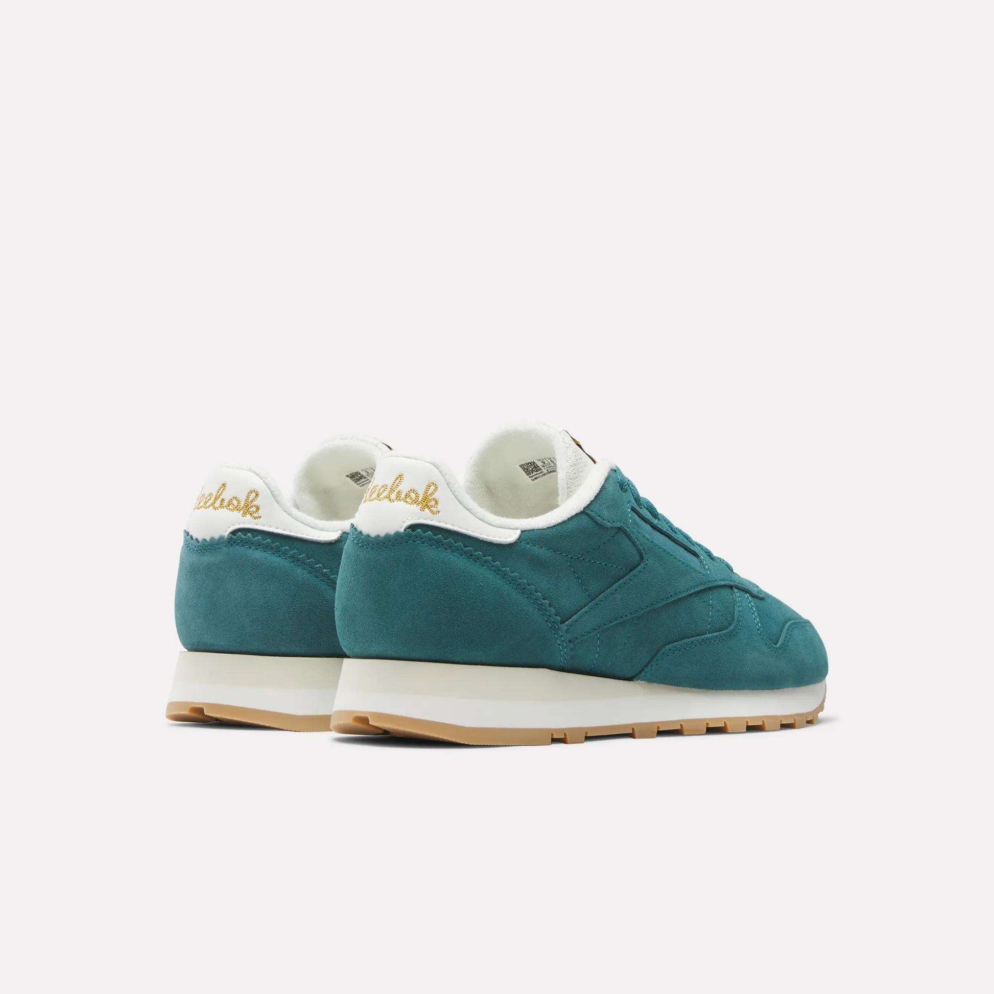 A pair of Reebok Classic Leather Shoes in teal with white midsoles, gum outsoles, and cream inner lining, displayed from the back and side on a plain white background—showcasing authentic Reebok style.