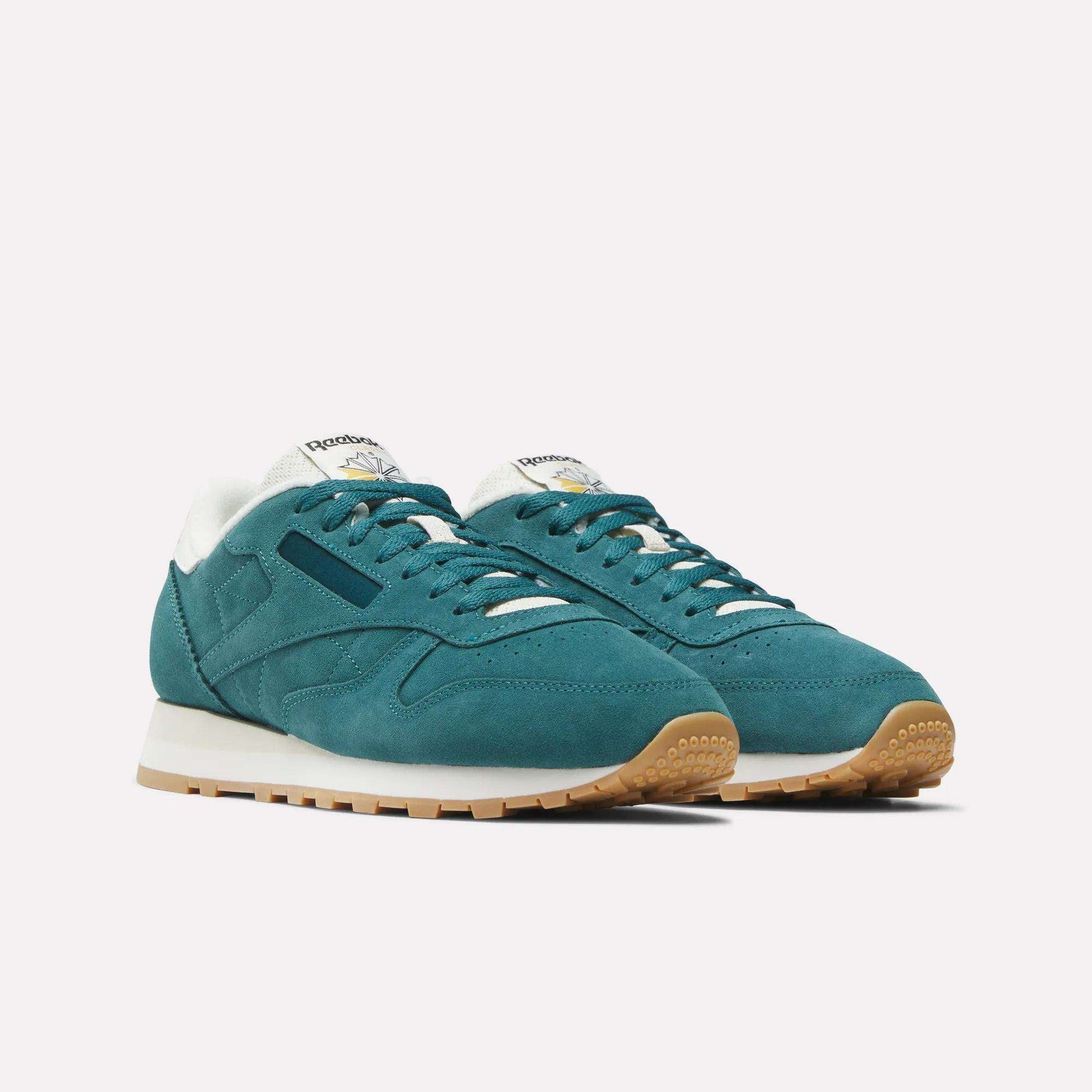 A pair of Reebok Classic Leather Shoes in teal with white midsoles, gum rubber outsoles, and white and blue tongue branding, displayed on a plain white background.