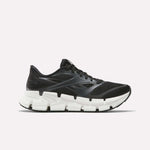 The Women's FloatZig 2 Running Shoes by Reebok are black, feature mesh and synthetic overlays, a chunky white segmented sole with Superfloat+ cushioning, and are shown from the side on a plain white background.