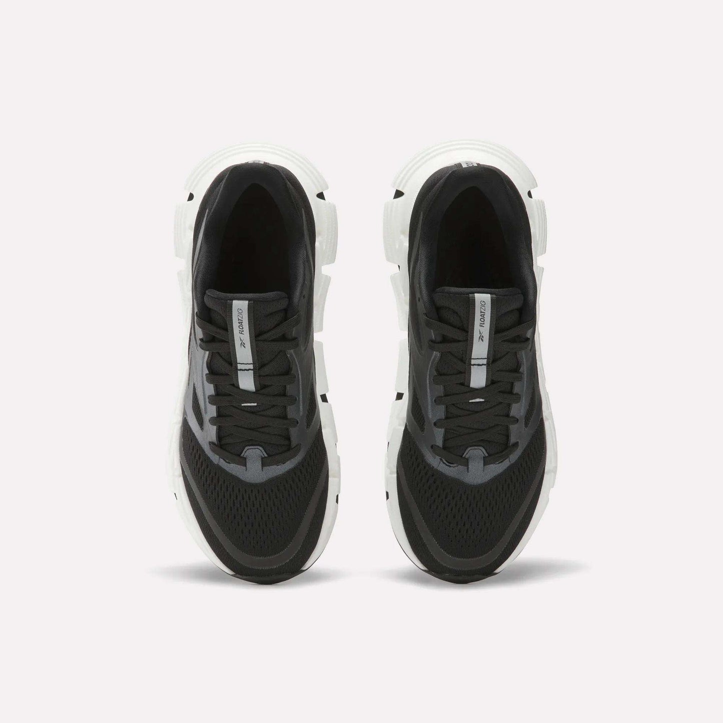 A pair of Women's FloatZig 2 Running Shoes by Reebok in black and white, shown from above with black laces, mesh uppers, and thick white soles featuring Superfloat+ cushioning on a plain white background.