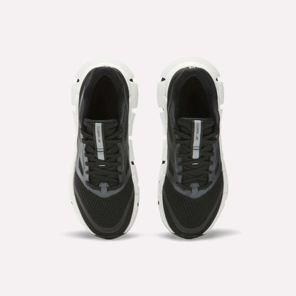 A pair of Women's FloatZig 2 Running Shoes by Reebok in black and white, shown from above with black laces, mesh uppers, and thick white soles featuring Superfloat+ cushioning on a plain white background.
