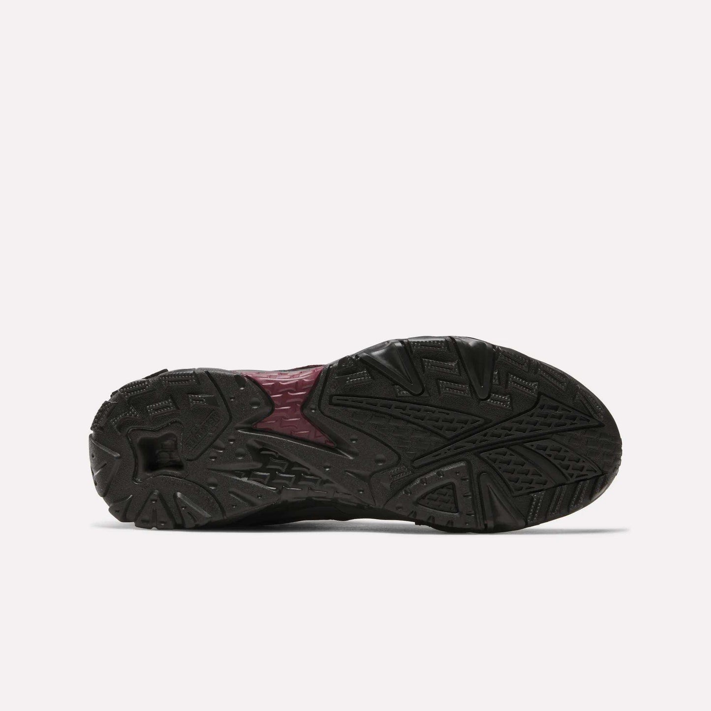 The image displays the bottom view of the Reebok Preseason 94 Low Retro Basketball Shoes, featuring a textured black rubber outsole with a maroon center section and traction grooves—classic elements of '90s Reebok training shoes.