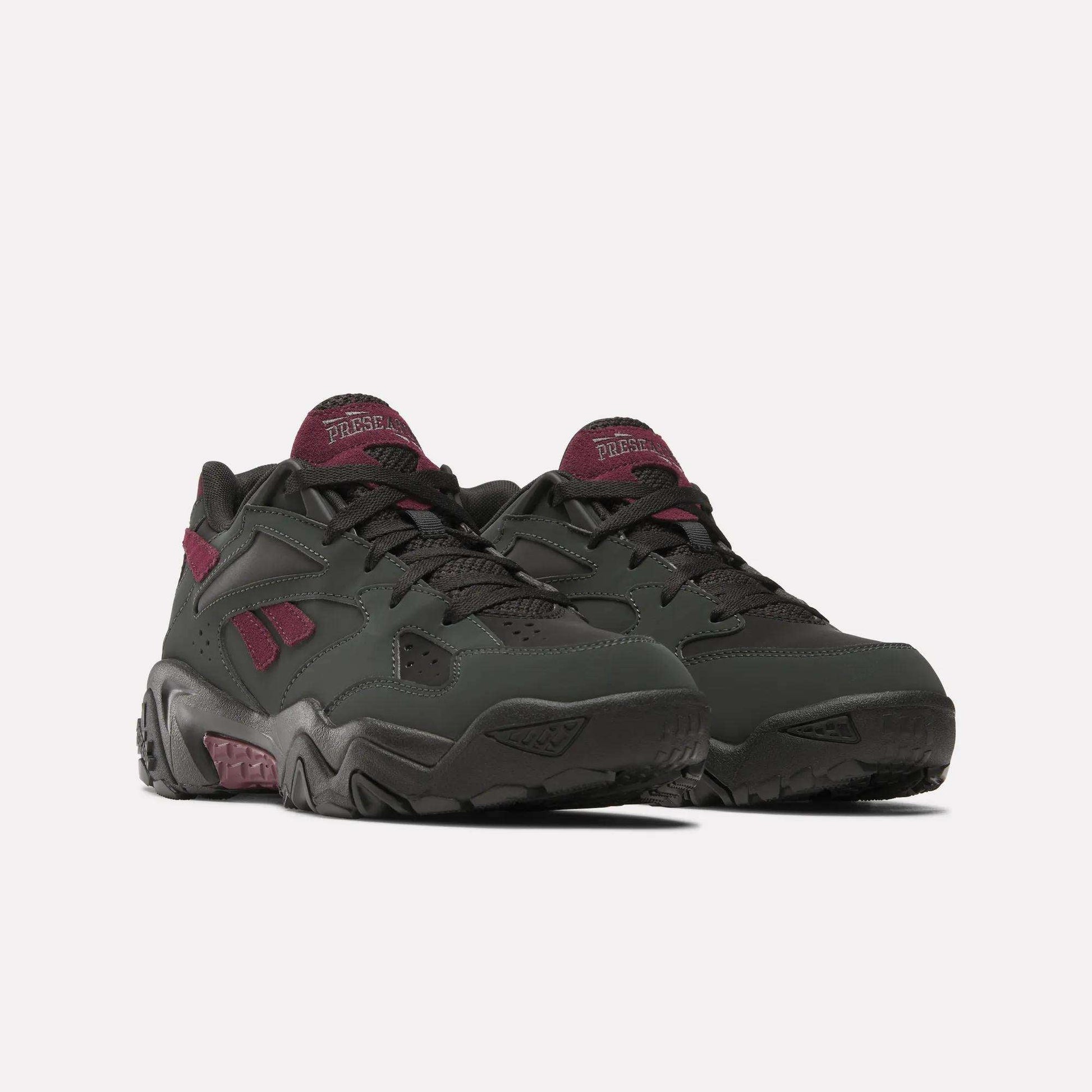 The Reebok Preseason 94 Low Retro Basketball Shoes are chunky, low-top sneakers in dark green with black soles and maroon accents, including logos, channeling '90s vibes. Displayed on a white background.