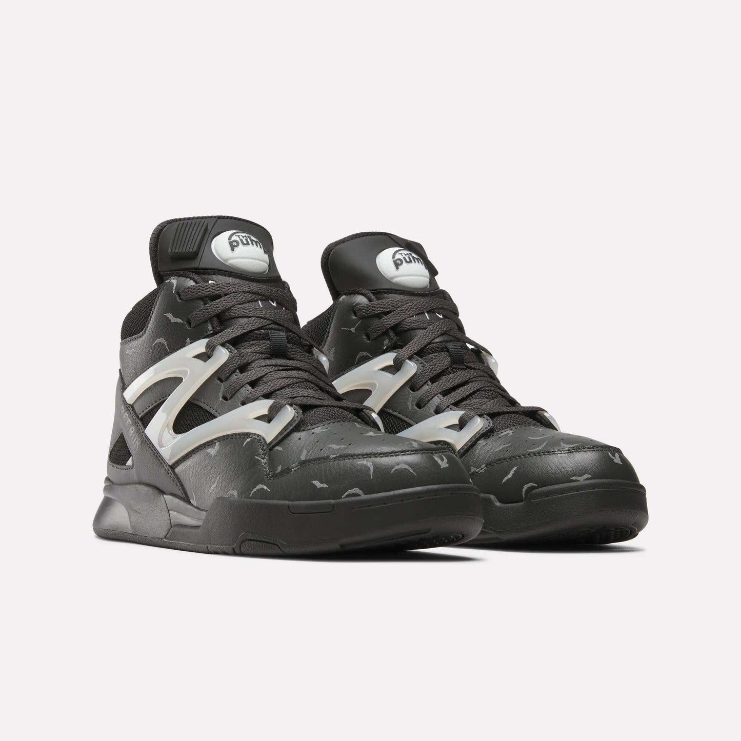 A pair of Reebok Pump Omni Zone II Retro Basketball Shoes in black with grey and reflective silver accents, thick black laces, and a chunky sole are displayed side by side on a plain white background.