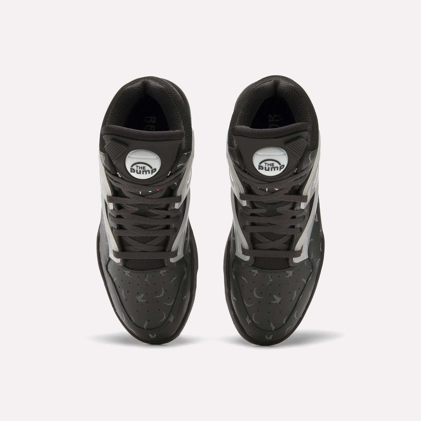 Top view of Reebok Pump Omni Zone II Retro Basketball Shoes with black uppers, white and reflective accents, dark gray laces, and white circular Pump patches on the tongues. The textured surface features small perforations.