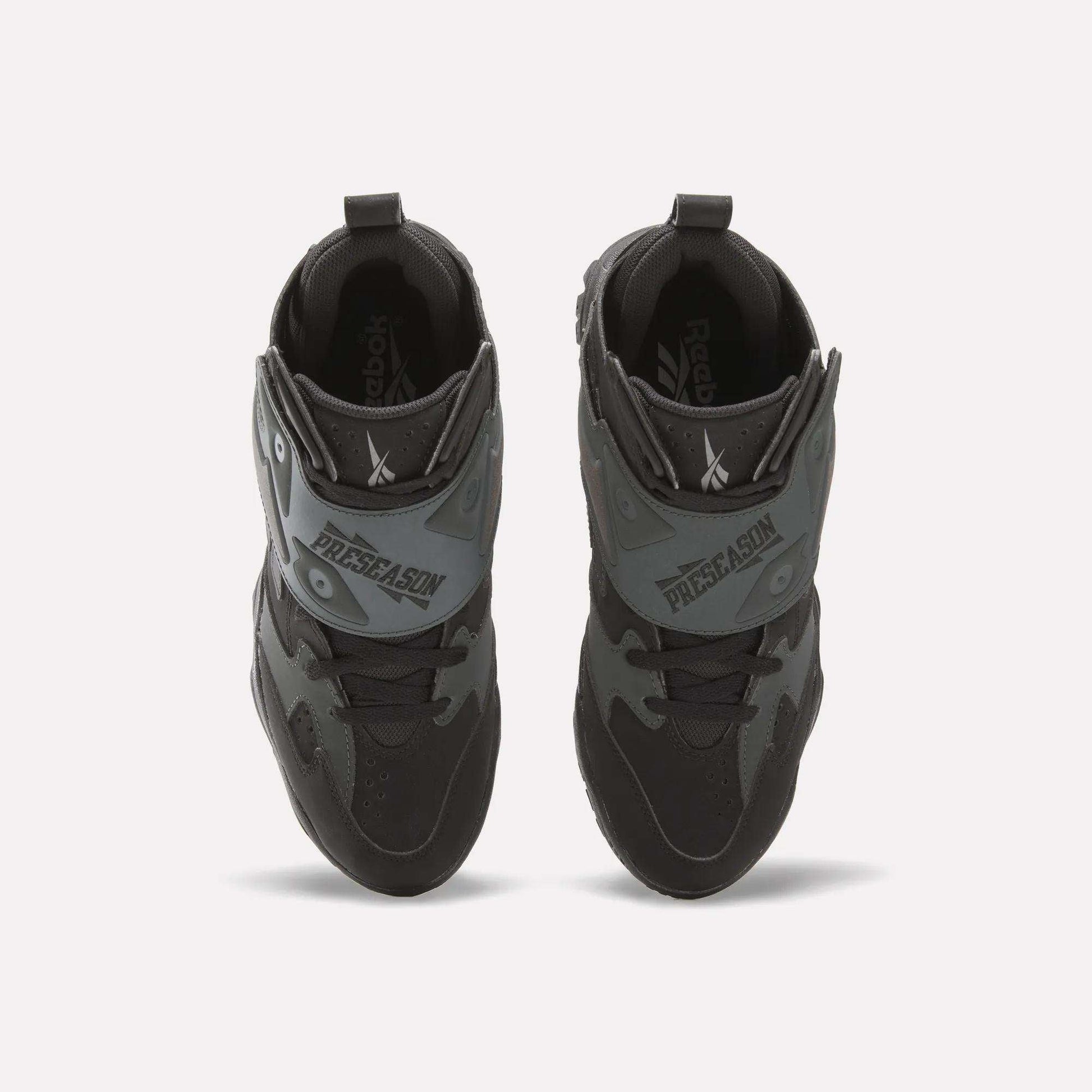 Top view of a pair of Reebok Preseason 94 Retro Basketball Shoes in black and gray with "PRESEASON" on the front straps, placed side by side on a white background.