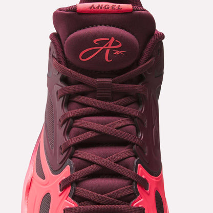 A close-up of the Reebok Engine A Basketball Shoes in burgundy and pink, showcasing the laces, tongue with a stylized A logo and "ANGEL" label—featuring SuperFloat foam for extra comfort.