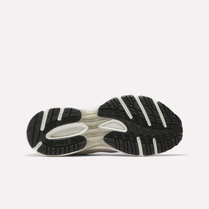 The image displays the black sole with white accents and textured tread of Reebok Women's Premier Trinity Shoes, highlighting their grip-focused design against a plain light background.