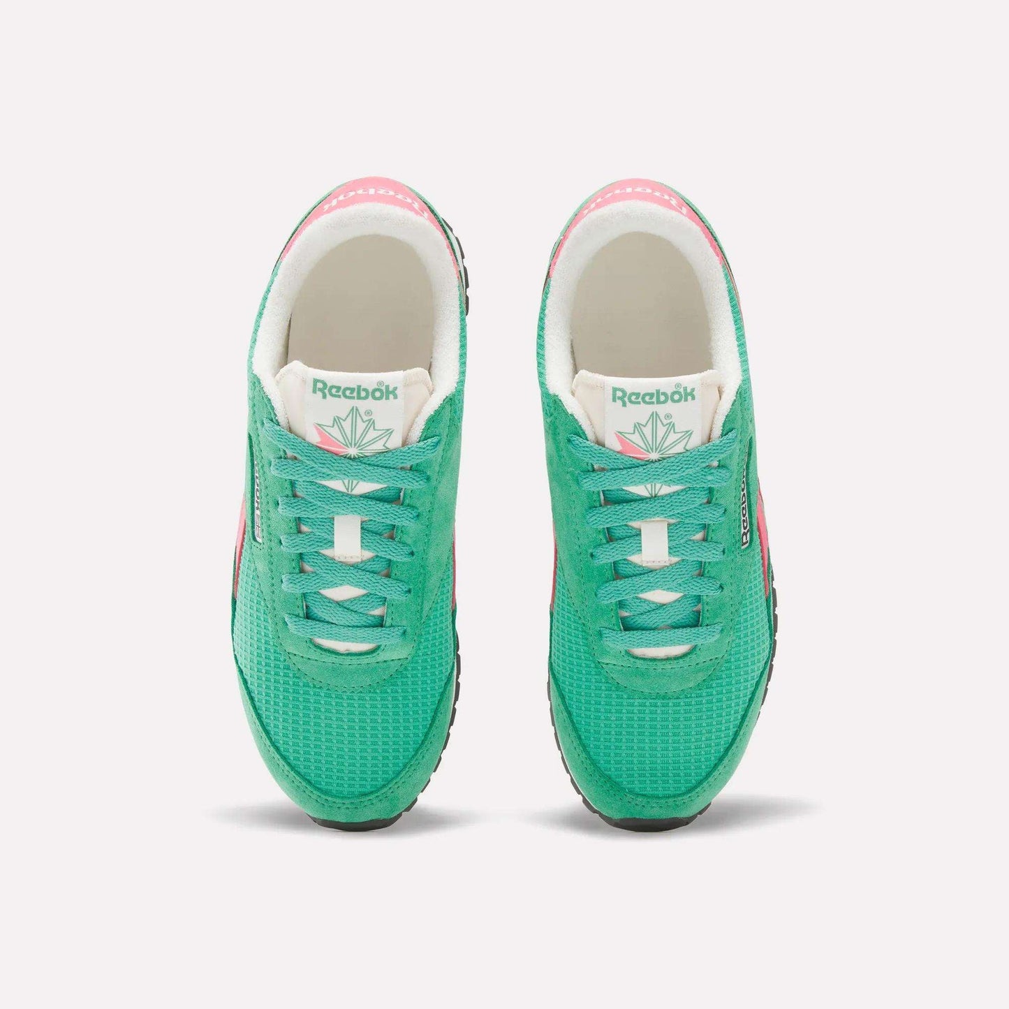 A top view of Reebok Women's Classic AZ Shoes in green, featuring white tongues, black soles, and pink accents on the sides and heels—an ideal pick for retro running shoe fans, displayed against a plain white background.