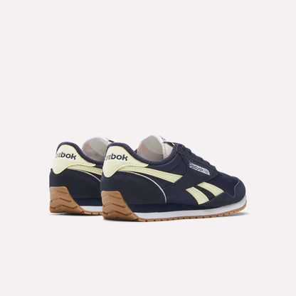 A pair of Women's Classic AZ Shoes by Reebok in navy blue with cream accents and gum soles, displayed at an angle to highlight the side and back against a light background, showcasing their vintage-inspired style.