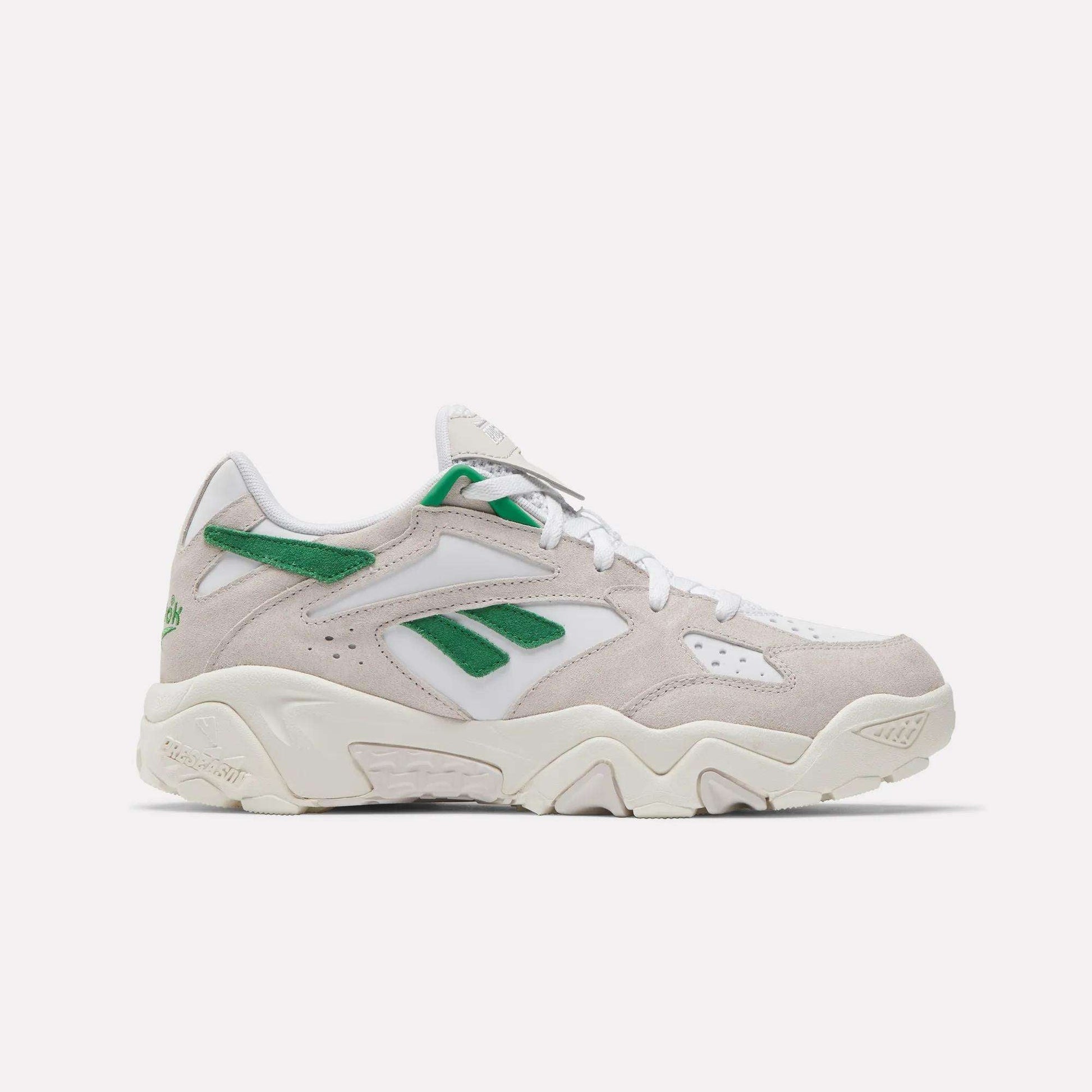 The Reebok Preseason 94 Low Retro Basketball Shoes feature a beige and white design with green accents, a chunky sole, and Reebok logos on the side and heel, inspired by '90s archive styles and shown against a plain white background.