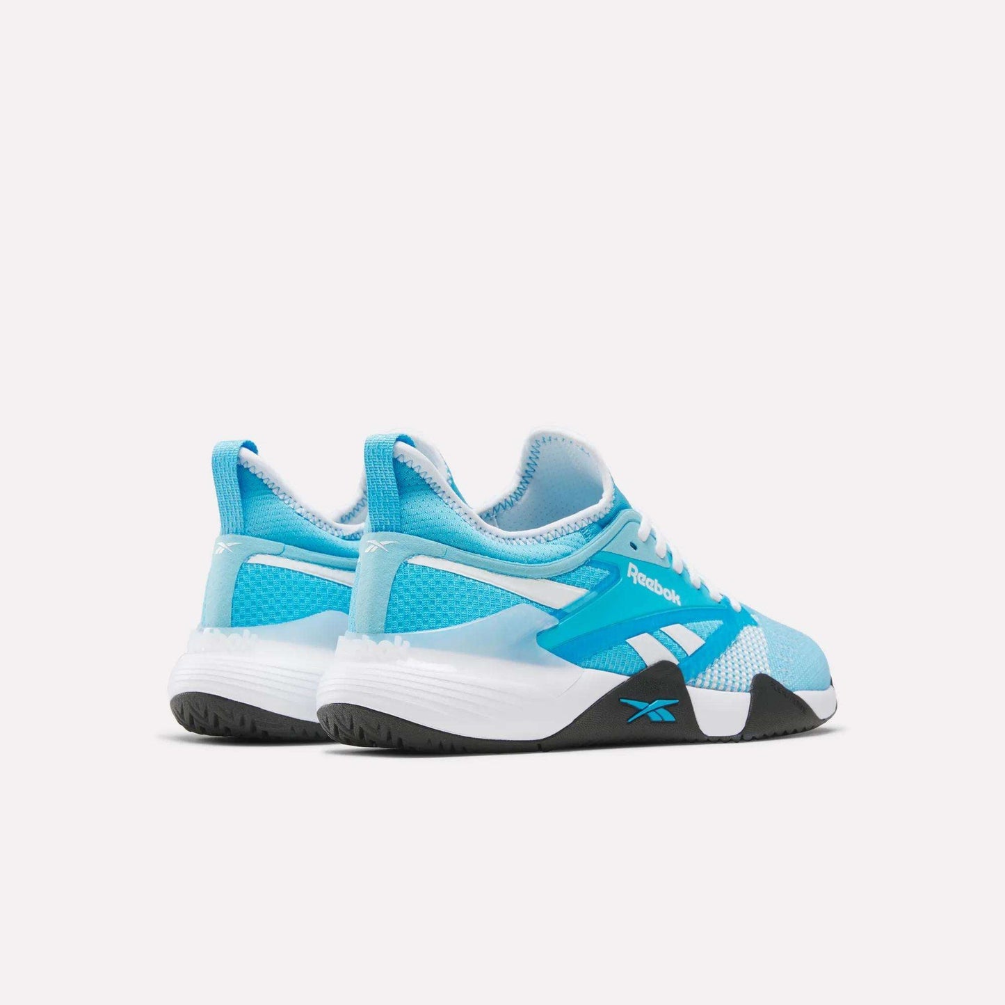 The Reebok Nano Court Shoes, in blue and white with black accents, designed for court sports, are shown from a rear-side angle on a plain white background.