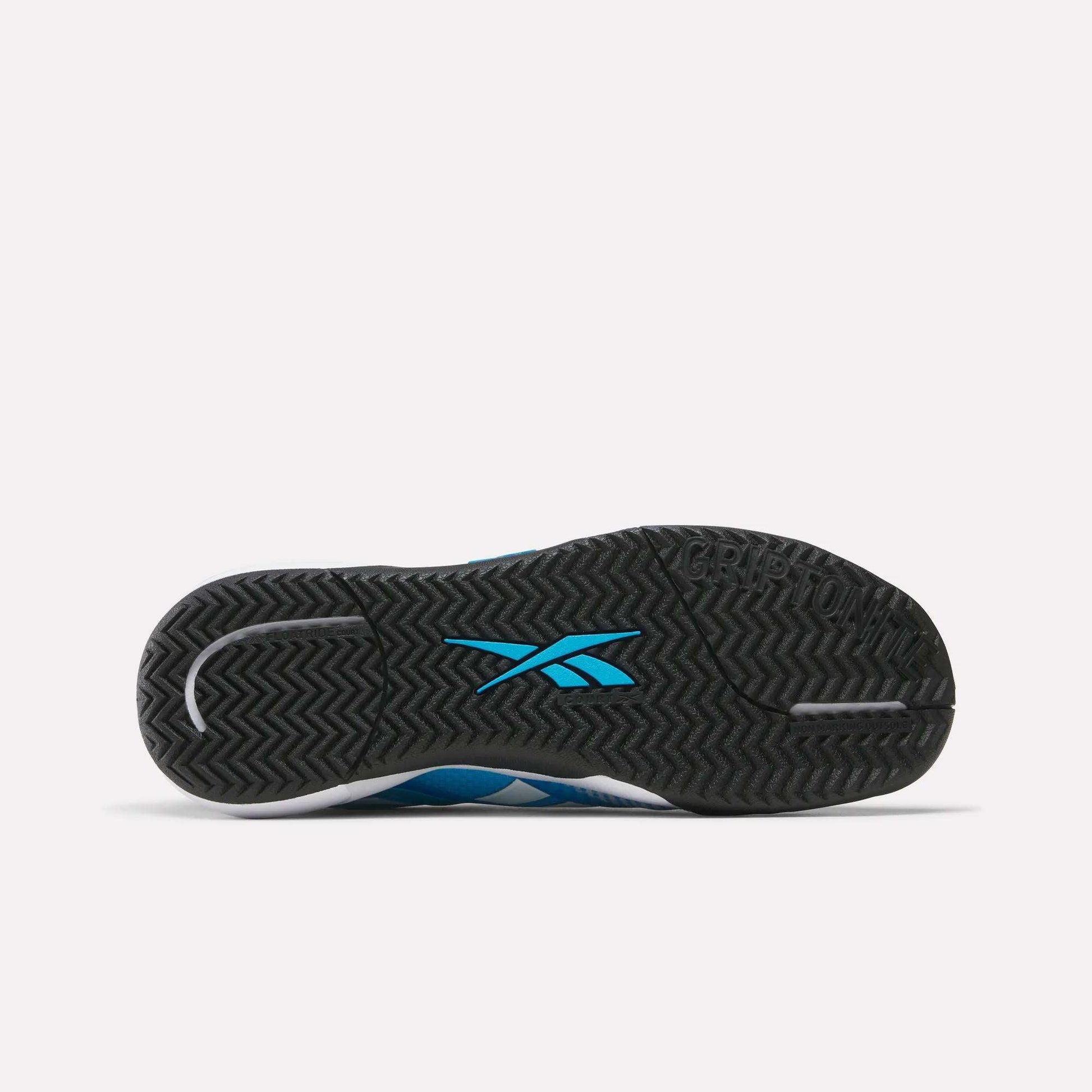 The image shows the black sole of Reebok Nano Court Shoes, featuring a blue Reebok logo at the center. The herringbone tread pattern and GRIPTON embossing near the toe provide multidirectional traction, ideal for court sports.