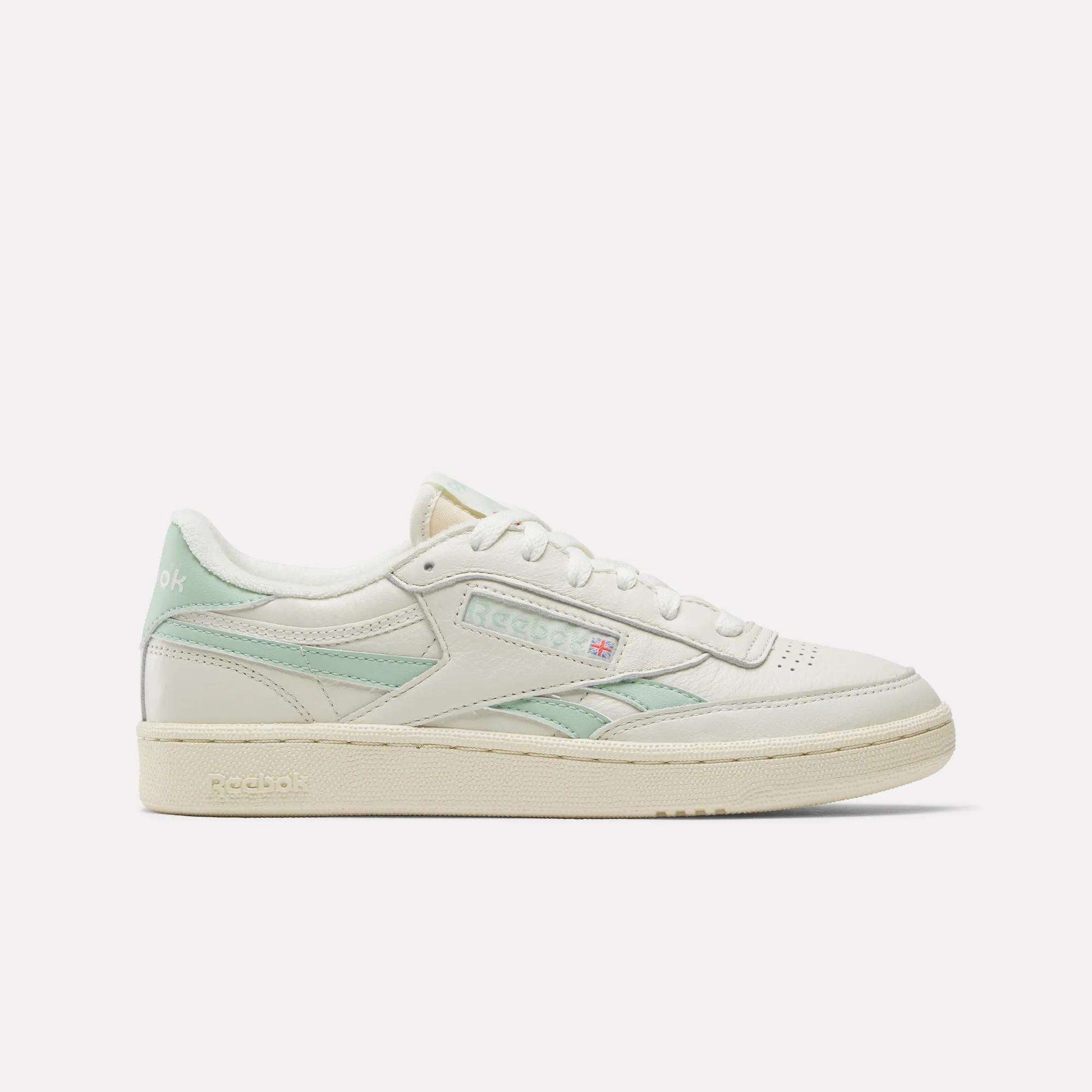 The Reebok Women's Club C Revenge Vintage Shoes are shown in cream with light green accents, displaying the Reebok logo and British flag in a side profile against a white background, echoing classic vintage style.