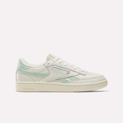 The Reebok Women's Club C Revenge Vintage Shoes are shown in cream with light green accents, displaying the Reebok logo and British flag in a side profile against a white background, echoing classic vintage style.