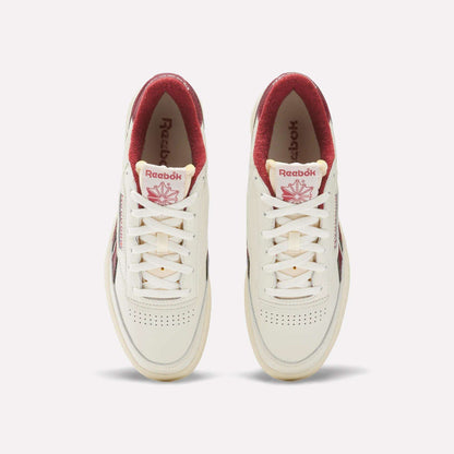 A pair of Reebok Club C Revenge Vintage Shoes are shown from above on a light background. These white sneakers feature red interiors and logos, subtle toe perforations, classic white laces, and full-grain leather uppers.