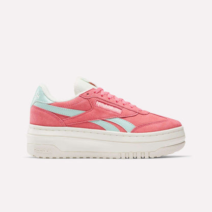The Reebok Campio Extra Women's Shoes are shown in pink with light blue side stripes, white laces, and a thick platform midsole, displayed in side profile against a plain white background.
