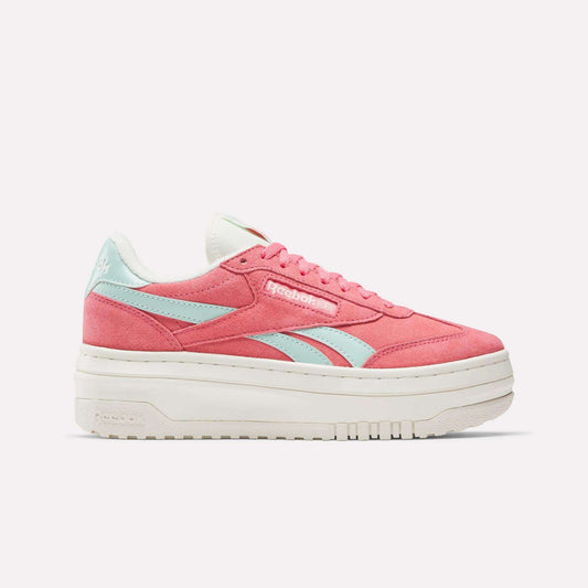 The Reebok Campio Extra Women's Shoes are shown in pink with light blue side stripes, white laces, and a thick platform midsole, displayed in side profile against a plain white background.