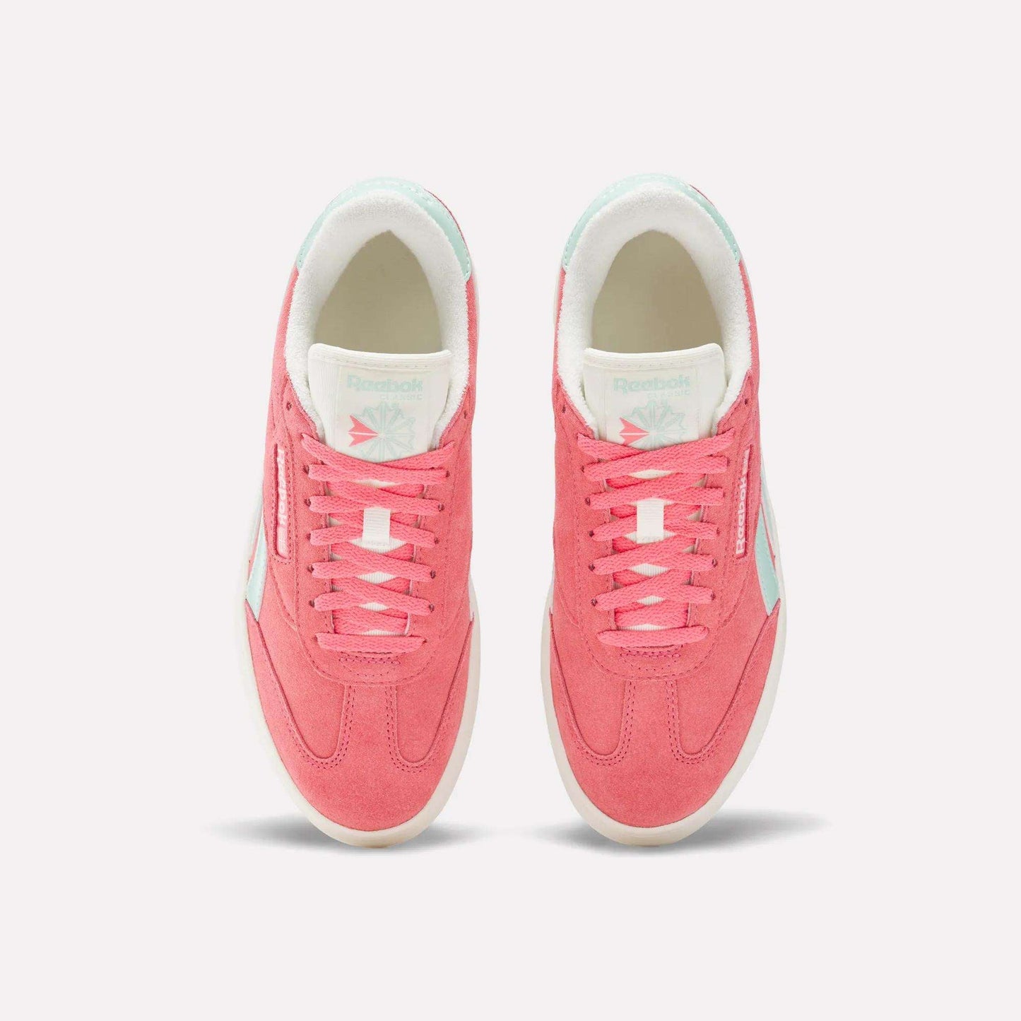 Top view of a pair of Reebok Campio Extra Women's Shoes in pink with white platform midsoles, pale blue accents, and white interior lining, displayed side by side on a plain light background.