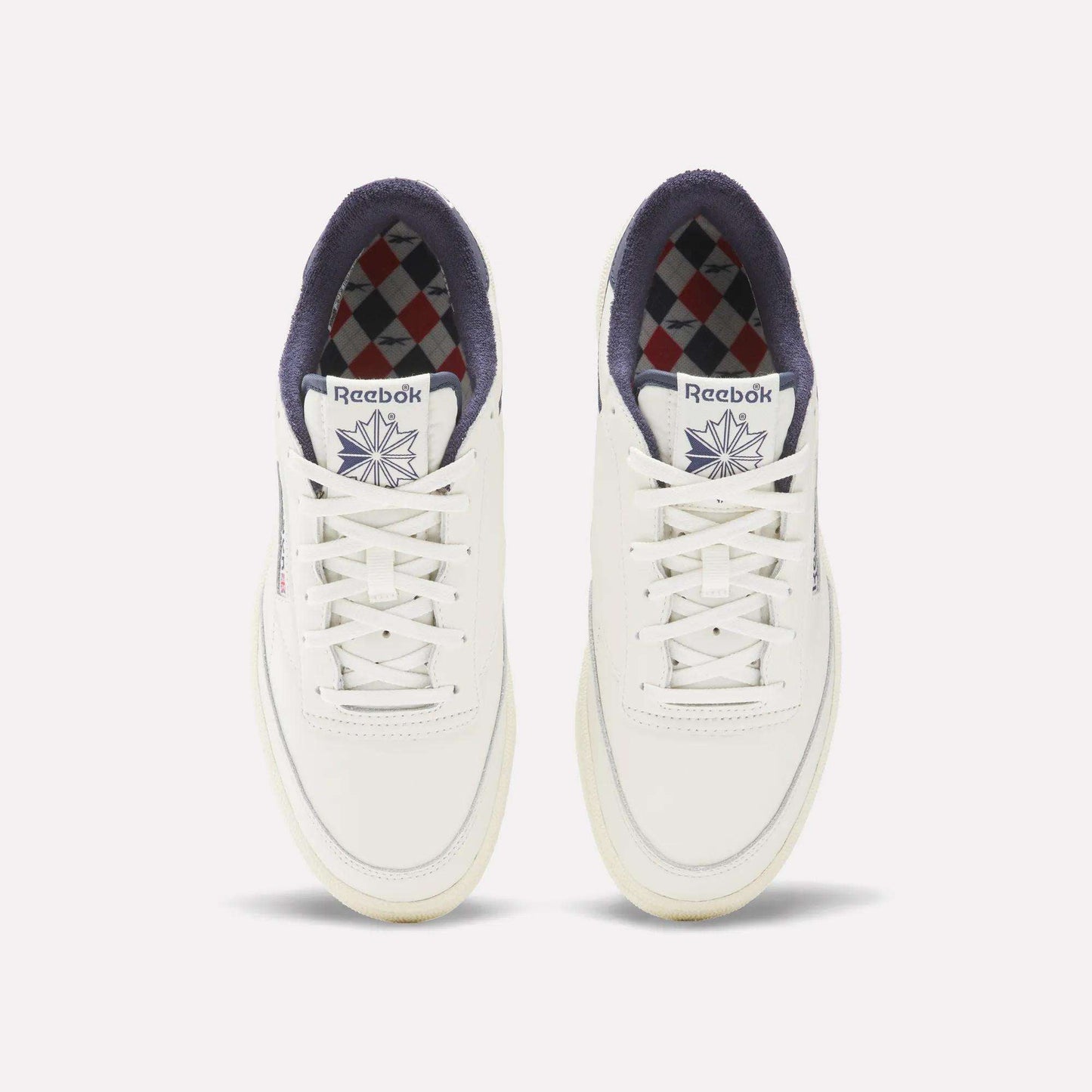 The Reebok Men's Club C Golf Shoes are white, made from water-resistant leather, and feature a spikeless outsole for all-day comfort on and off the course.