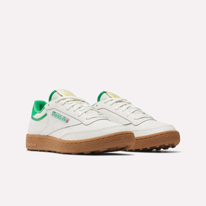 Men's Club C Golf Shoes by Reebok in white with green accents, a gum rubber spikeless outsole, and the Reebok logo on the side, shown against a plain white background.